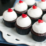 Mini Chocolate Cupcakes with Meringue and Raspberry - Delicious dark chocolate mini cupcakes, filled with raspberry jam and topped with the fluffiest meringue and a cute little heart. Perfect for Valentine's Day! | thetoughcookie.com
